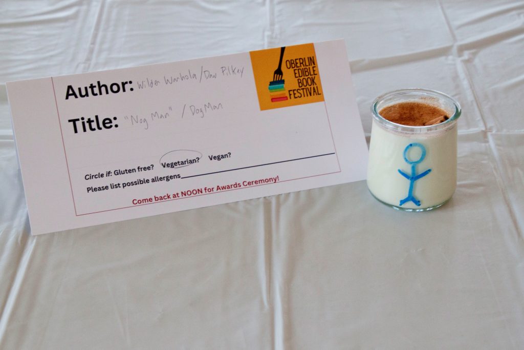 Photo of submission titled, "Nog Man" featuring a glass of egg nog with a stick figure drawn on the glass