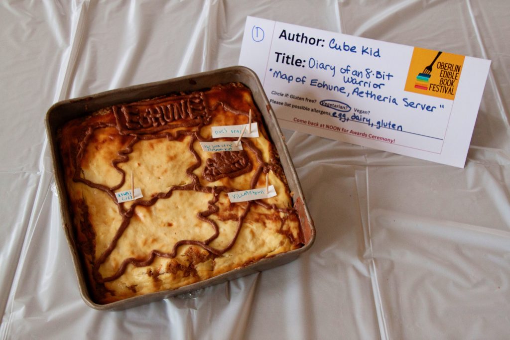 Photo of submission titled, "Diary of an 8-Bit Warrior" featuring a cake with a map of Eohune, Aetheria Server in chocolate icing