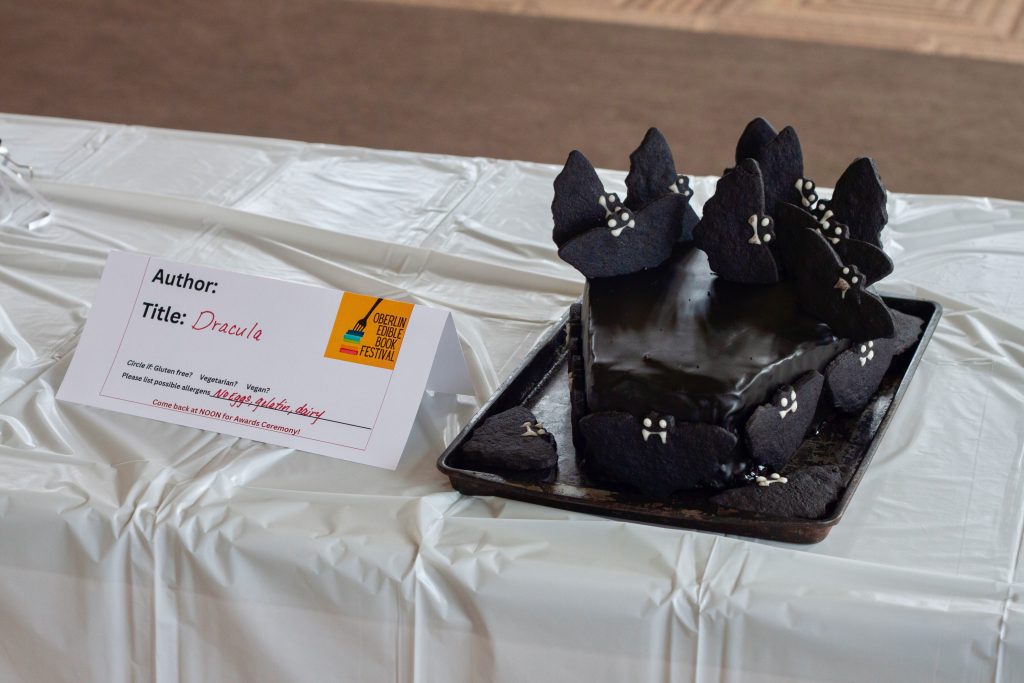 Photo of submission titled, "Dracula" featuring a coffin shaped black cake with bat-shaped cookies surrounding it
