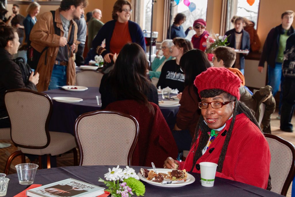 Attendee smiles at the camera with her plate of samples